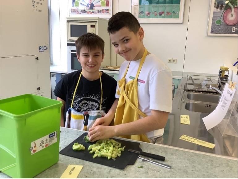 Zwei Schüler beim Gemüse schneiden