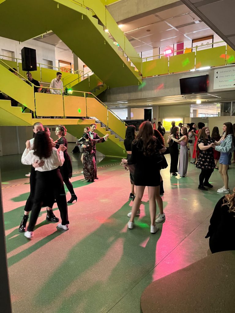 Schülerinnen und Schüler tanzen in Kleider