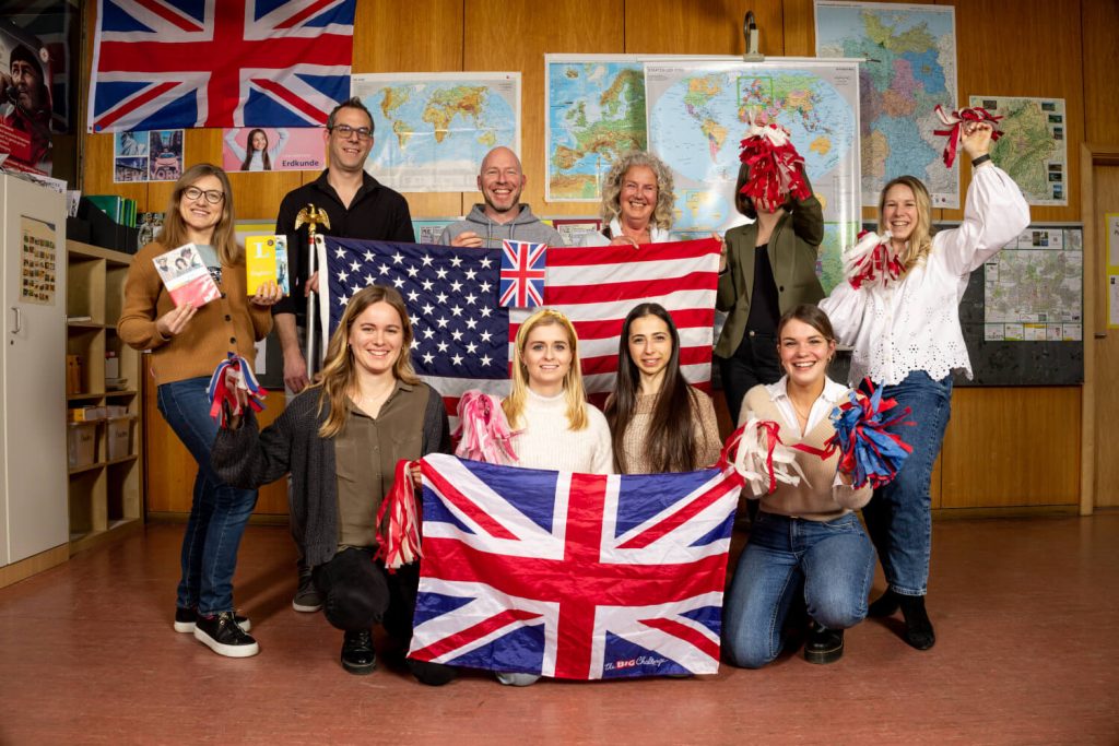 Die Englisch Lehrerinnen und Lehrer halten USA und Großbritannien Flaggen hoch